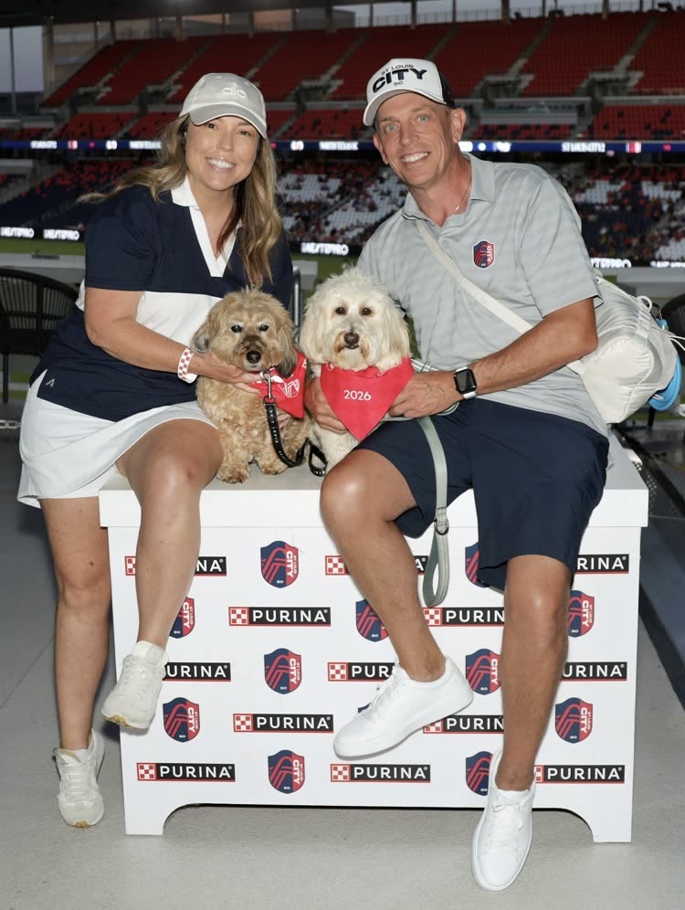 Ashley and Steve with their two dogs at a stadium