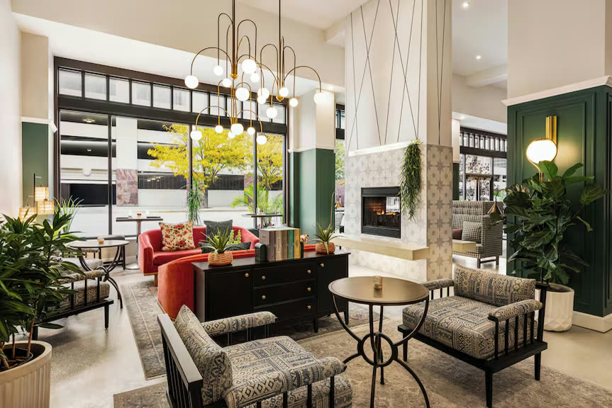 The Magnolia Hotel lobby with a fireplace and chandeliers